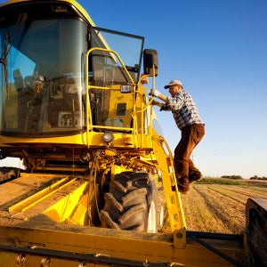 A farmer performing a fall farm equipment inspection